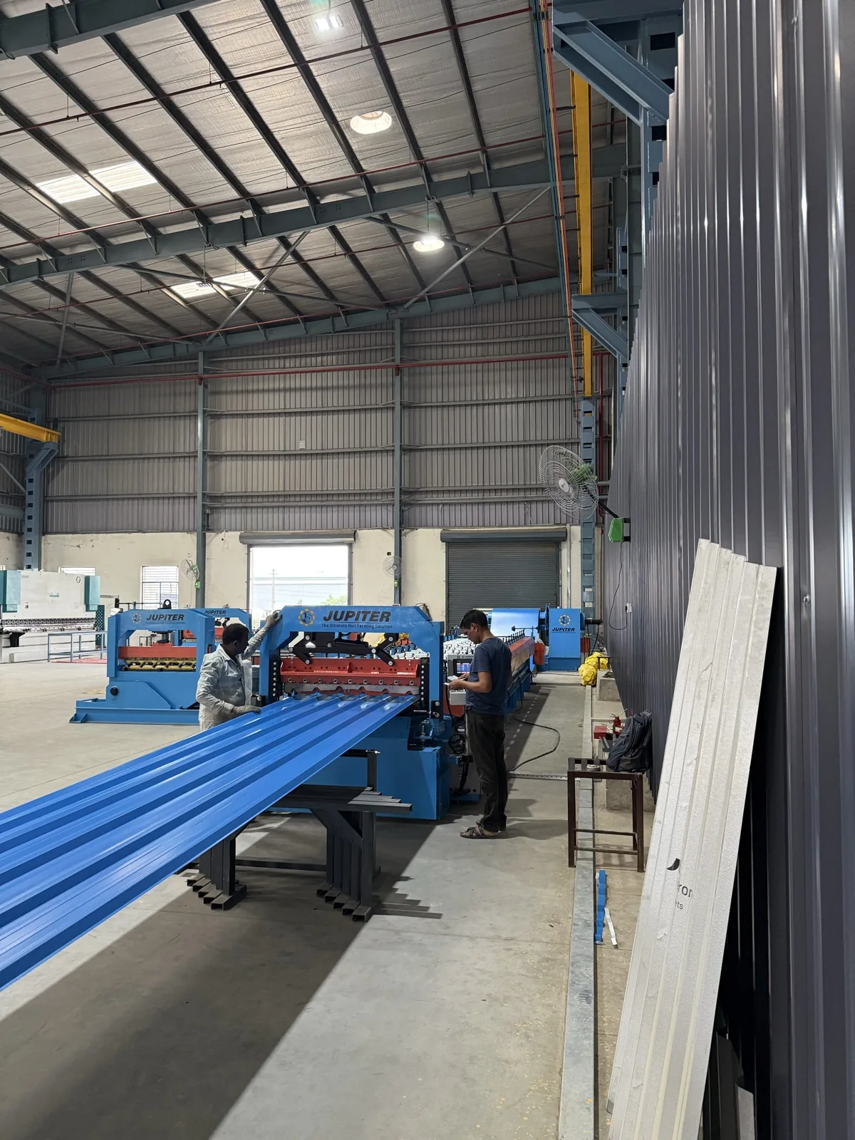 Colour-coated profile sheet emerging from the roll-forming line
